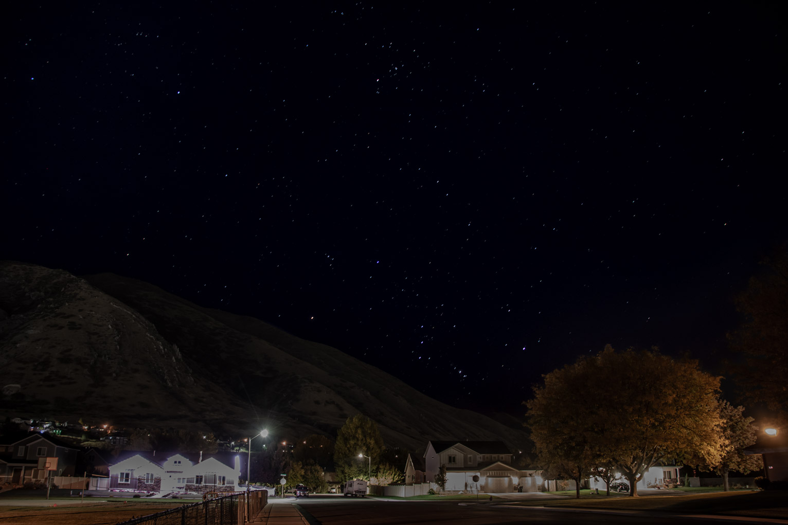 over houses and a park Orion rises just above the mountain, Taurus visible above